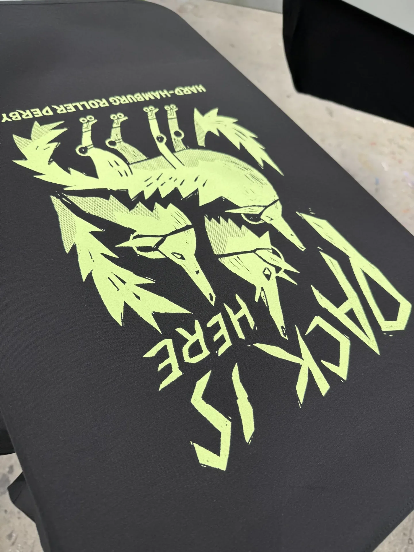 Schwarzes T-Shirt mit neongrünem Glow-in-the-Dark-Siebdruck für Roller Derby, TIME/LESS Prints Hannover.