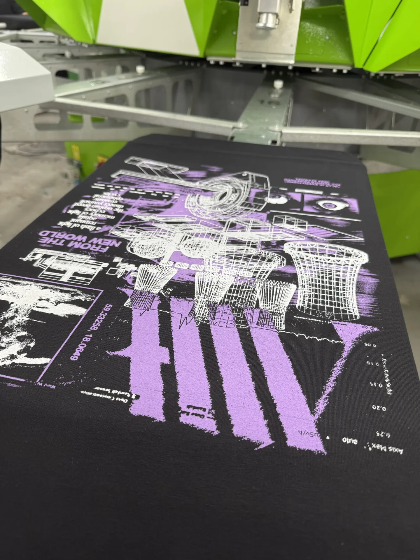 Zweifarbiger Siebdruck in Lila und Weiß auf schwarzem Bandmerch-Shirt für die Band ALLT, an der Siebdruckmaschine bei TIME/LESS Prints Hannover.