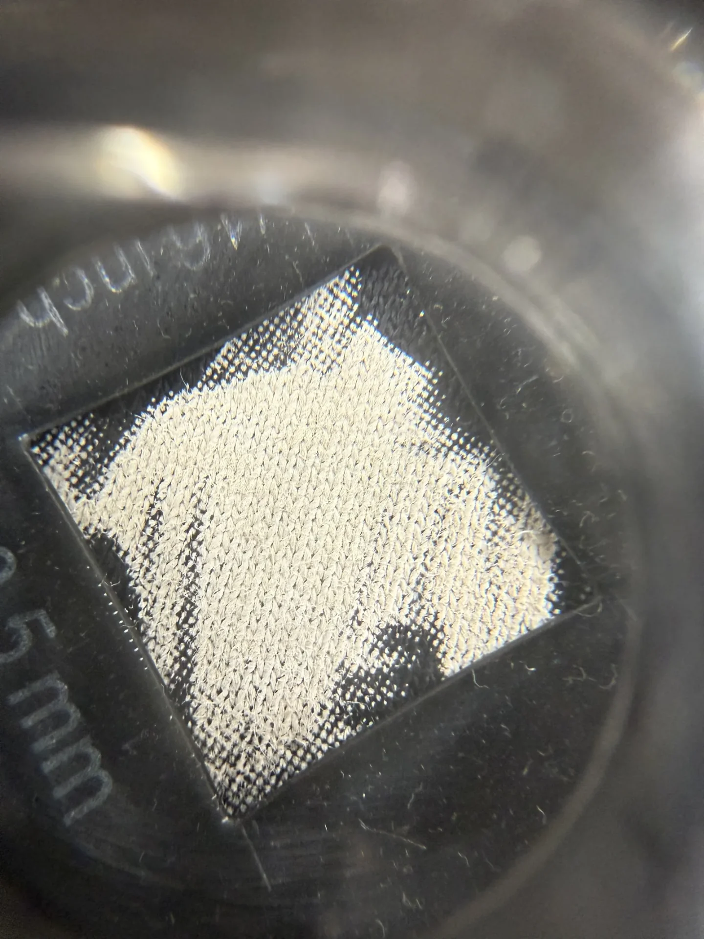 Detailaufnahme eines weichen Discharge-Drucks auf dunkler Baumwolle, TIME/LESS Prints Hannover.