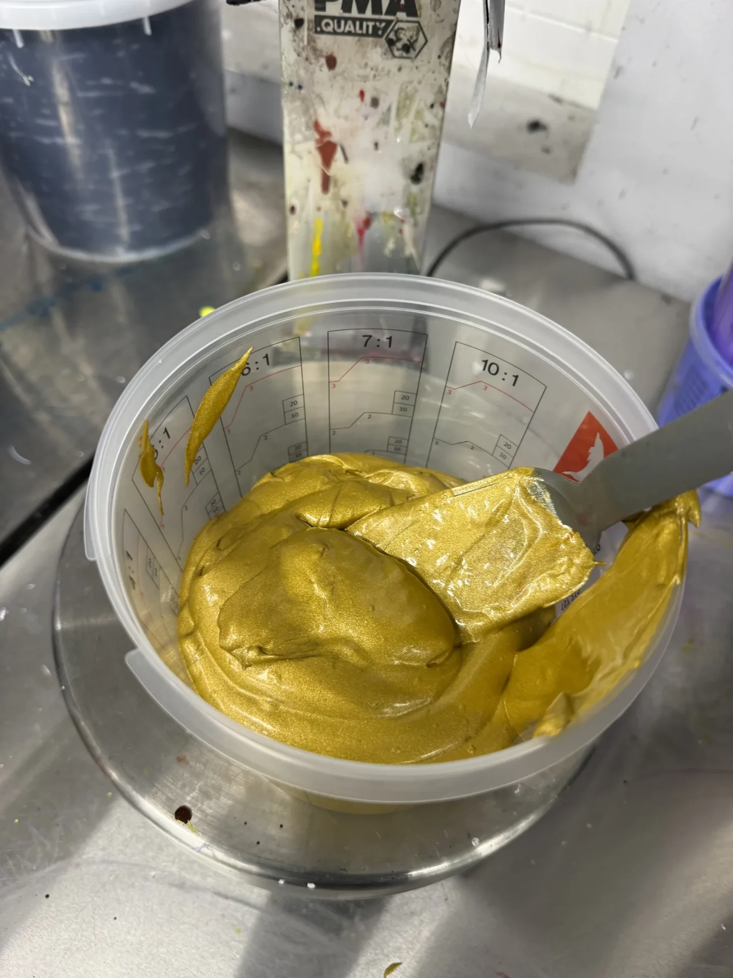 Wasserbasierte Metallic-Gold-Siebdruckfarbe wird im Mischbecher angerührt, TIME/LESS Prints Hannover.