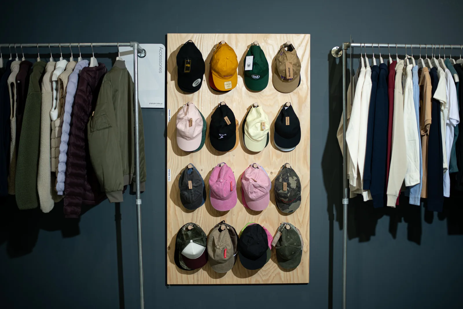 Cap wall with embroidered caps in the TIME/LESS Prints showroom.