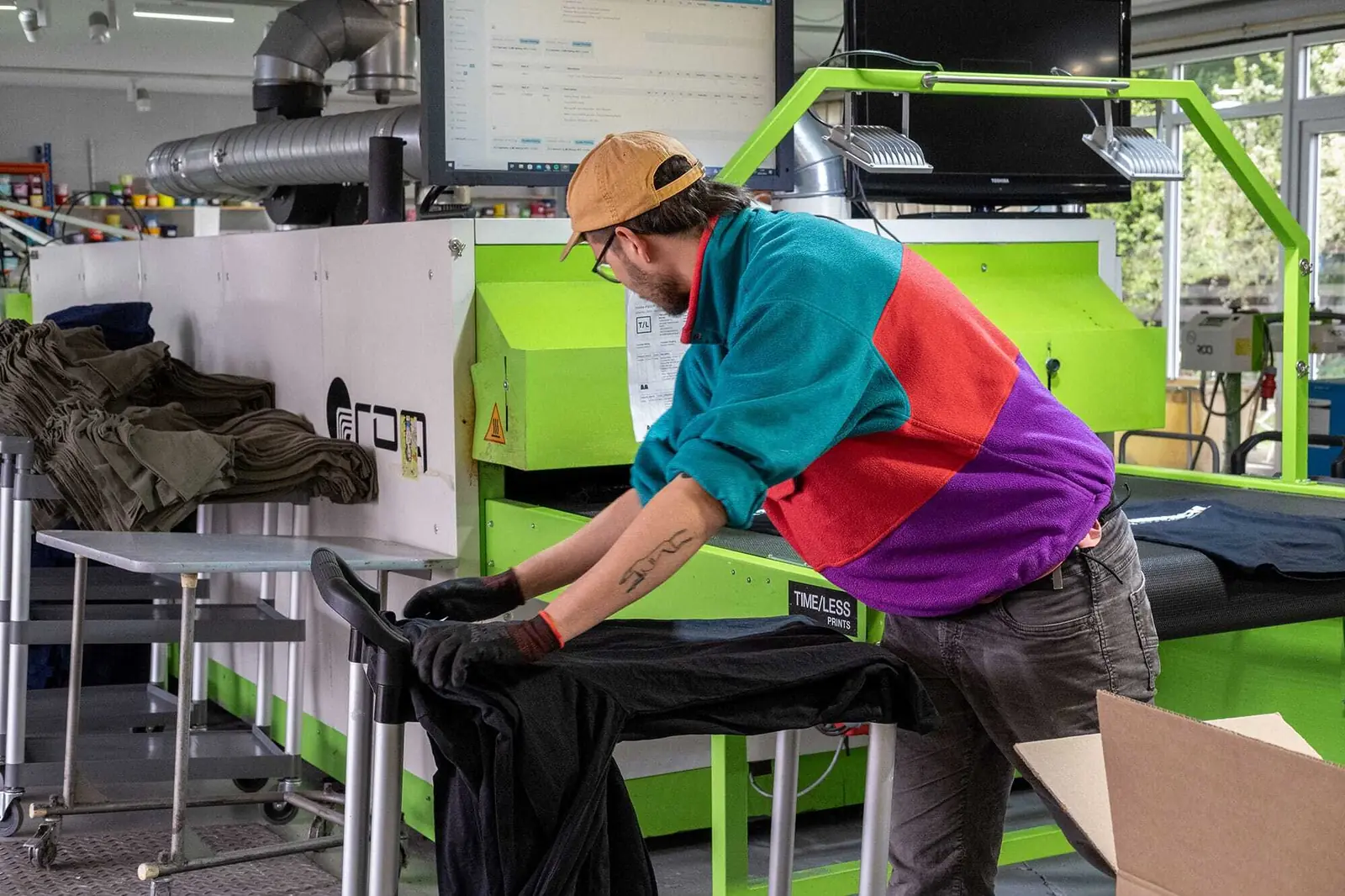 Person beim Falten von fertig bedruckten T-Shirts.
