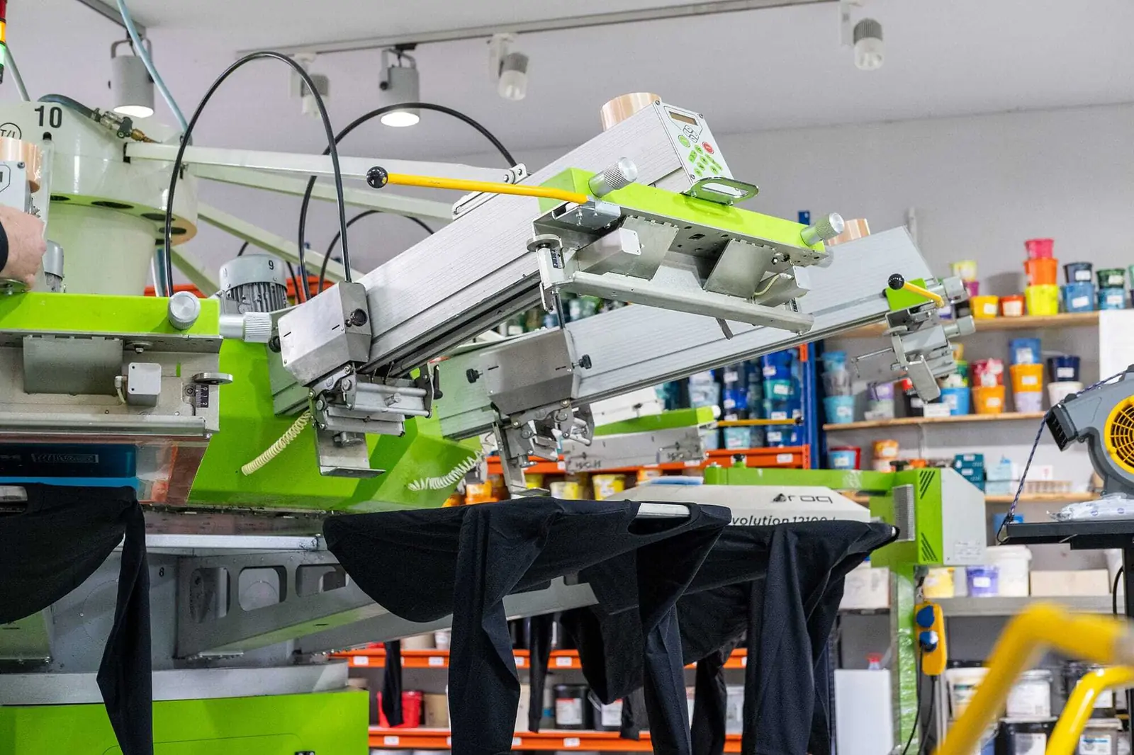 Eine Frau bei der Arbeit an einer Siebdruckmaschine bei TIME/LESS Prints in Hannover.