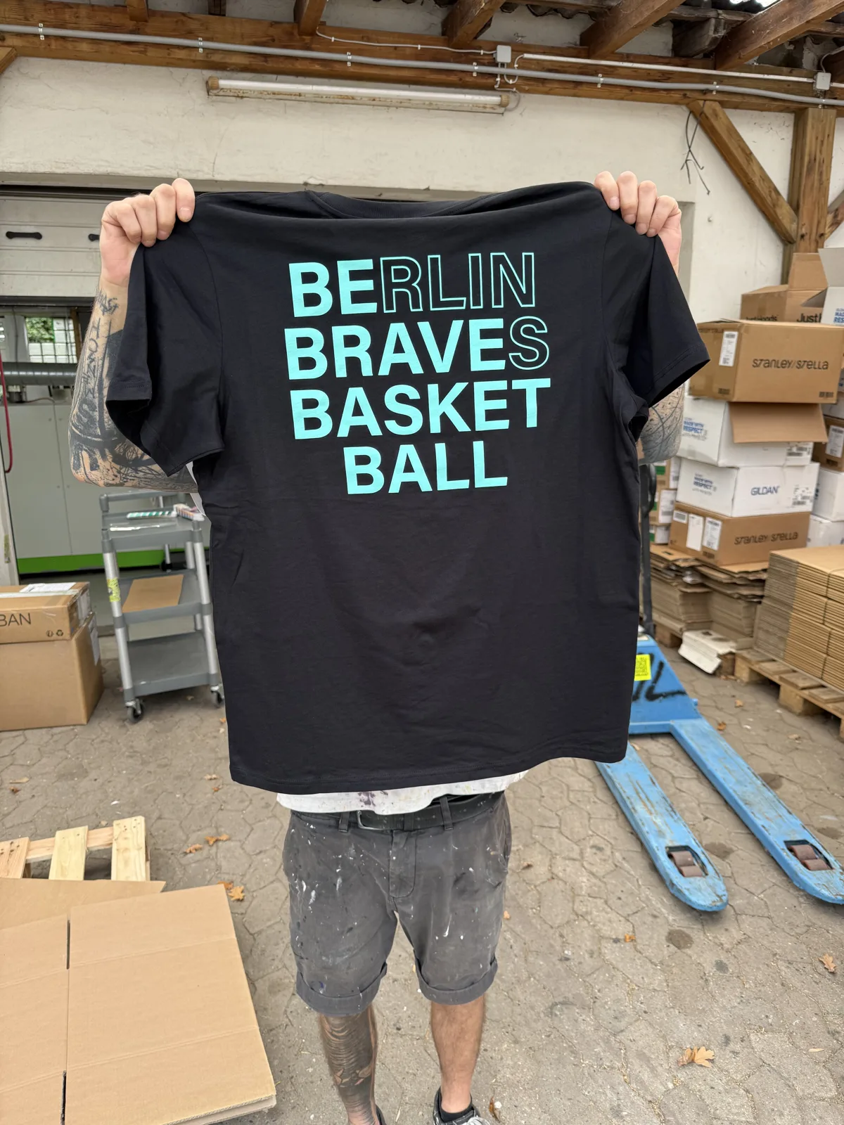 Schwarzes Vereinsshirt mit türkisem Schriftzug eines Basketballvereins im Siebdruck bei TIME/LESS Prints.
